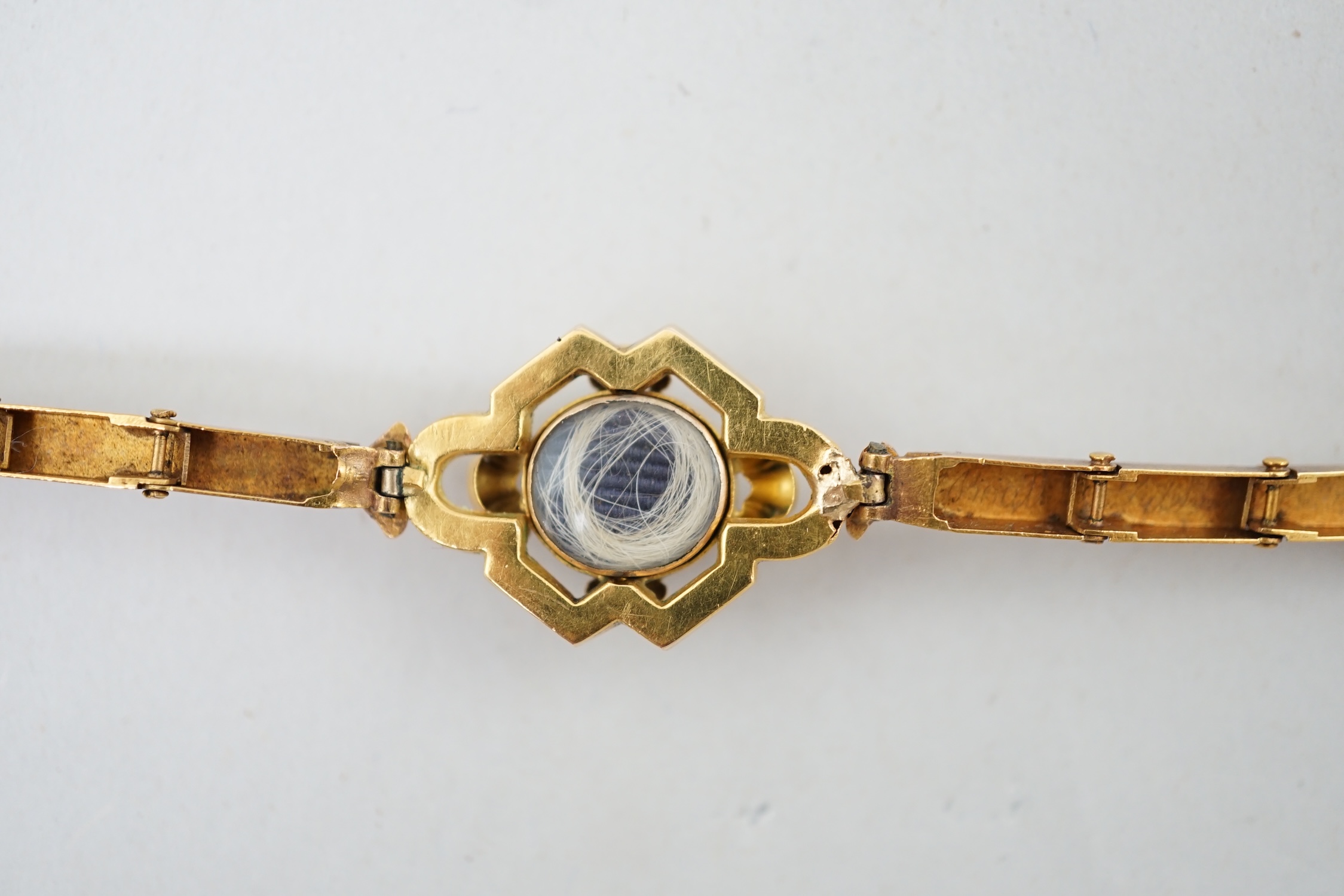 An early 19th century engraved gold and cabochon garnet set mourning bracelet